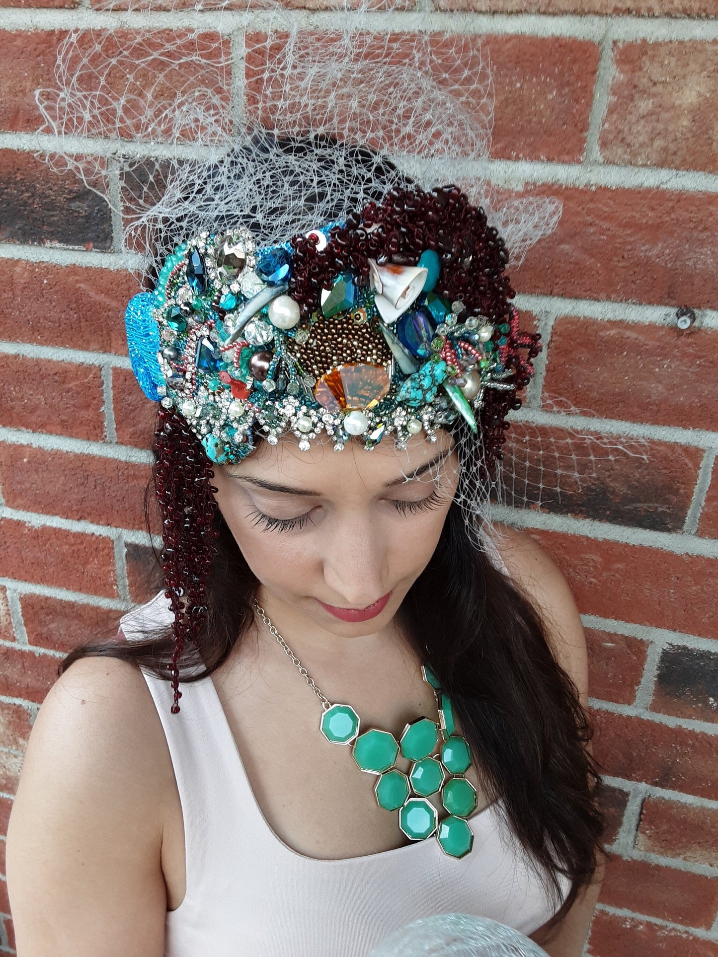 A richly detailed crown featuring cascading coral forms, hand-sewn crystals, and ocean-inspired elements.