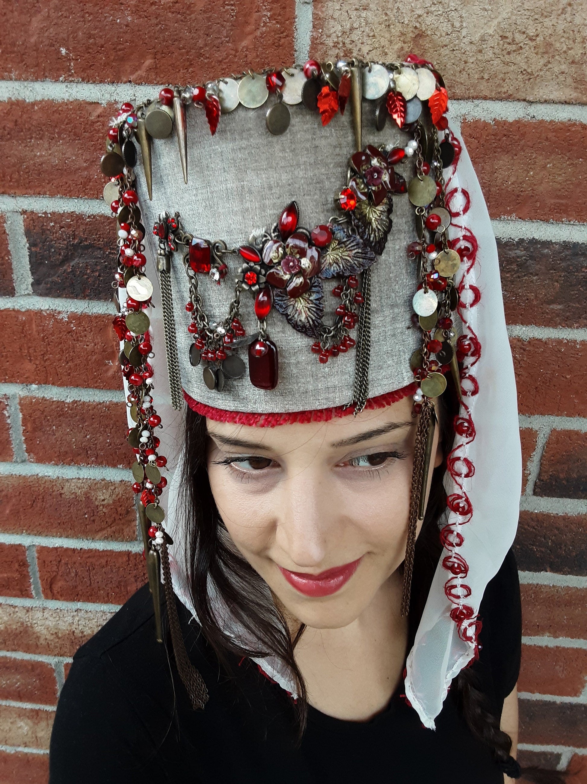 A vintage-inspired, hand-sewn crown with ornaments, coins, beads, and flowing veil detail.