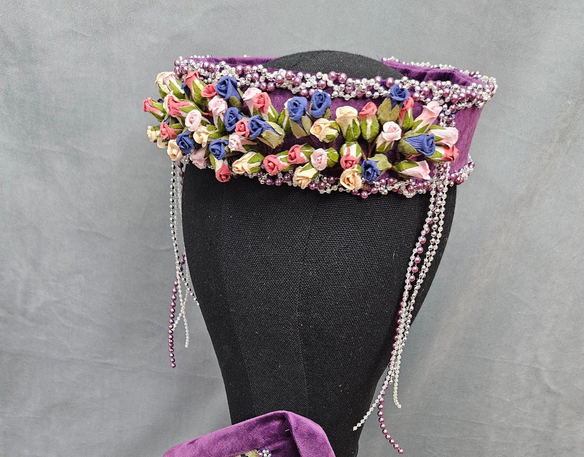 Decorative headpiece with floral and beaded details on a mannequin 