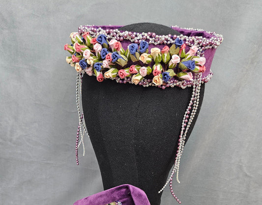 Decorative headpiece with floral and beaded details on a mannequin 